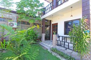 ein Haus mit einem Tor und Pflanzen davor in der Unterkunft Jmt star's inn in General Luna