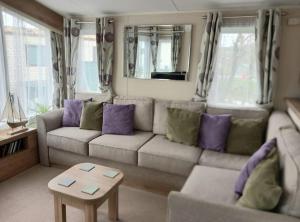 a living room with a couch and a table at Lagooncombe modern and cosy holiday home in Haverigg