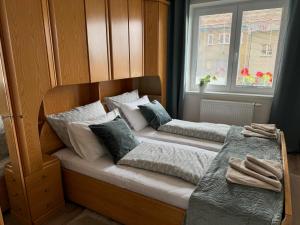 a bed with two pillows on it next to a window at Ubytovanie pri hradbách in Levoča