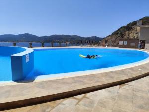 a person laying on a surfboard in a swimming pool at Sa Roca in Campionna