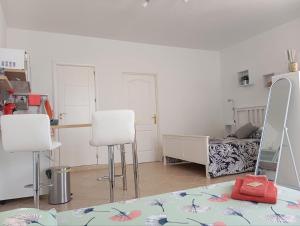 una camera con due sedie bianche e un letto di Las Buganvillas 77 a Playa Blanca Altre 20 foto