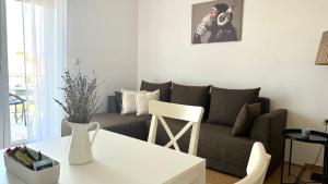 a living room with a couch and a table at Apartments Ein Haus in der Sonne in Malinska