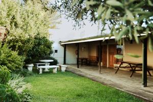 a house with a picnic table and benches in the yard at The Grey's Inn in Machadodorp