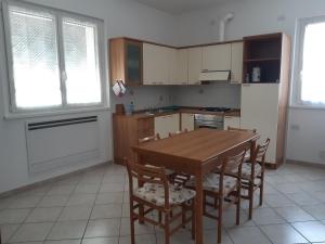 a kitchen with a wooden table and chairs and a kitchen with a refrigerator at Casa Morgana a Villatico in Colico