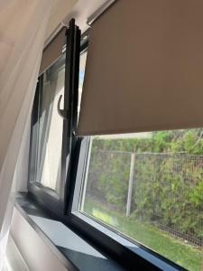 une fenêtre dans une pièce avec vue sur un arbre dans l'établissement Sky Residence Airport Therme Otopeni 5, à Otopeni