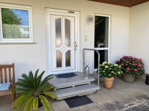 a front door of a house with a porch with flowers at Ferienwohnung Orts-Idyll in Erlenbach am Main