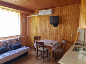 a room with a table and a couch and a tv at Цар Калоян in Primorsko