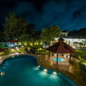 a swimming pool with a gazebo at night at Khushana Villa by Baywatch stayzz in Chennai