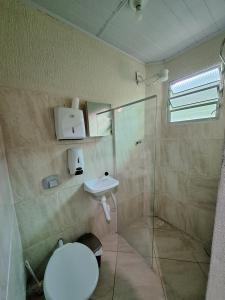 a bathroom with a shower and a toilet and a sink at Pousada Imperial in Itaboraí