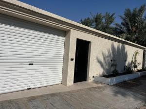 a garage door of a house with a driveway at Cove Chalet 1شاليه كوڤ in Al Ahsa