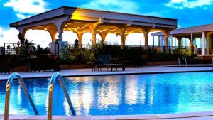 a swimming pool with a gazebo next to a building at The Country Lodge Hotel in Freetown