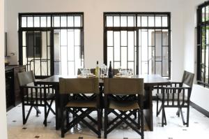 a dining room with a black table and chairs at OYA Guest House in Usa River +35 photos