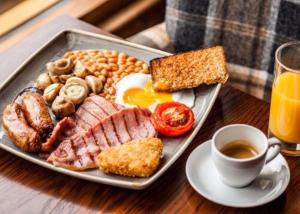 a plate of breakfast food on a table with a cup of coffee at The Swallow Falls Inn - The Inn Collection Group in Betws-y-coed +128 photos