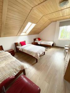 a room with three beds and a wooden ceiling at Agroturystyka Aksamitka in Lubiąż
