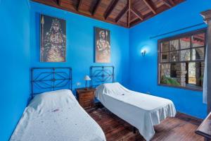 two beds in a room with blue walls at Casa Rural La Venta in Santa Cruz de Tenerife +36 photos