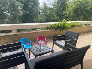 two chairs and a table and chairs on a patio at Appartement avec parking & linge inclus & local vélos in Blois