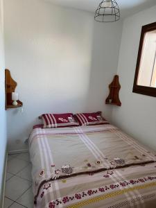 a bed in a white room with purple pillows on it at Appartement centre Saint Gervais-Vue imprenable in Saint-Gervais-les-Bains