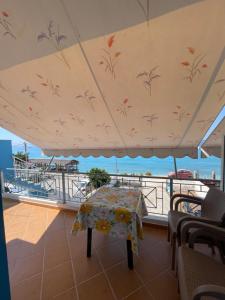a table on a balcony with a view of the ocean at Vila Gusti in Borsh +7 photos