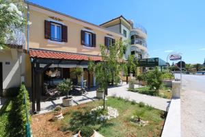 een straatbeeld van een gebouw met bomen in een tuin bij Villa Galleria in Sukošan