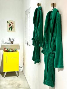 a bathroom with green towels hanging on a wall at Suítes - Village Capixaba in Gravatá