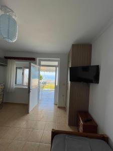 a living room with a television and a view of the ocean at Vila Gusti in Borsh