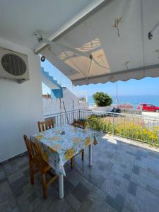a dining room table with chairs and a view of the ocean at Vila Gusti in Borsh