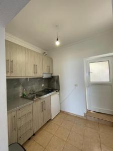 an empty kitchen with a sink and a window at Vila Gusti in Borsh