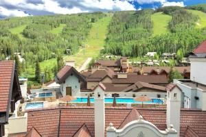 a group of buildings with a mountain in the background at Platinum 3 Bedroom Vacation Rental In The Heart Of Vail That Includes Ski Valet, Ski Deck, Rooftop Pool, Panoramic Views in Vail