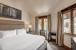 a bedroom with a large white bed and windows at 4 Bedroom Luxury Townhome In Lionshead Village in Vail +22 photos