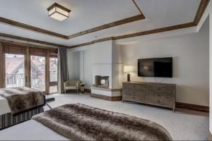 a large bedroom with a bed and a television at Platinum 4 Bedroom Vacation Rental In The Heart Of Vail That Includes Ski Valet, Ski Deck, Rooftop Pool, Panoramic Views in Vail +12 photos
