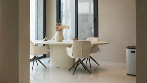 a dining room table with chairs and a vase on it at Villa Pacifica Nador in Nador