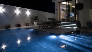 a swimming pool with a couch and a chair in a house at Villa Pacifica Nador in Nador