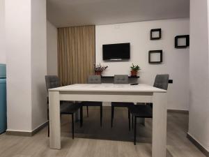 a dining room with a white table and chairs at Apartamento La Avenida in Lanjarón