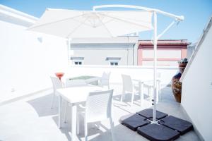 a white table and chairs and an umbrella on a balcony at Bed & Breakfast Terra d'Arneo in Leverano