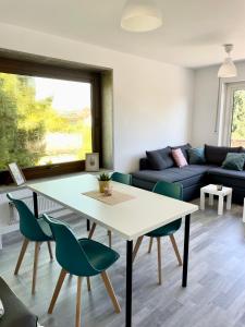 - un salon avec une table blanche et des chaises vertes dans l'établissement Apartment mit Balkon, Stein bei Nürnberg, à Stein bei Nürnberg