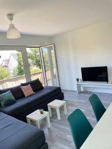 - un salon avec un canapé noir et des fauteuils verts dans l'établissement Apartment mit Balkon, Stein bei Nürnberg, à Stein bei Nürnberg 29 autres photos