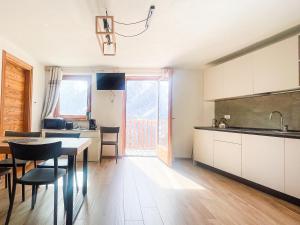 a kitchen and dining room with a table and chairs at I tre corvi - Rocca Bianca in Prali