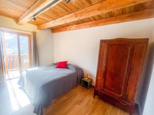 a bedroom with a bed and a wooden cabinet at I tre corvi - Rocca Bianca in Prali