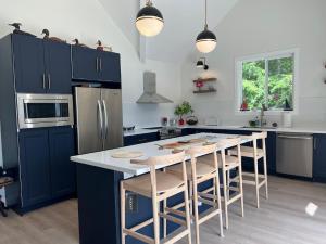 una cucina con armadi blu e un'isola cucina con sgabelli da bar di Davi's Lake House a Torrance