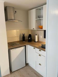 a kitchen with white cabinets and a sink at Bo's Apartment 35 in Schwäbisch Hall +10 photos