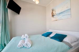 ein Schlafzimmer mit einem Bett mit Handtüchern darauf in der Unterkunft Horyzont by Baltic Home in Misdroy + 80 Fotos