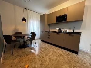 a kitchen with a table and chairs in a room at Catullo Lounge and Rooms Near The Airport in Caselle