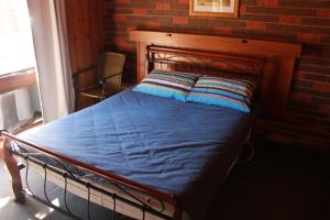 a bed in a room with a brick wall at Kalamunda 2 in Bright
