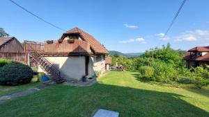 a house with a green yard with a roof at Chatka przy kapliczce in Bugaj