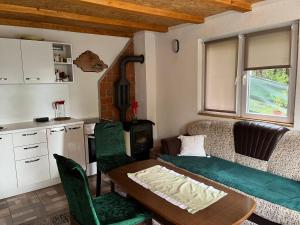 a living room with a table and a kitchen at Vikendica Amra i Indir in Travnik