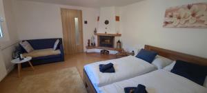 a living room with two beds and a fireplace at Privát Stelly in Dolná Lehota