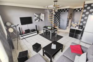 a living room with a couch and a tv at Duplex les pieds dans l'eau in Grandcamp-Maisy