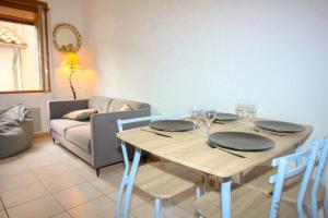 a dining room with a table and chairs and a couch at Maison de village Can Mahdia in Prats-de-Mollo-la-Preste