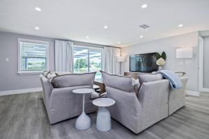 Una sala de estar con dos sofás y un televisor. en Infinity Retreat, en Port Richey