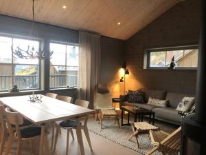フネスダーレンにあるFunäsdalsfjällen för skidor, cykel, vandring och fiskeのテーブルとソファのあるリビングルーム